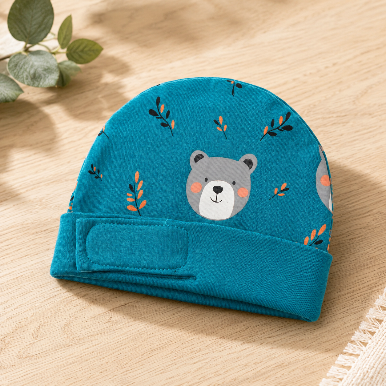 Teal teddy bear-print preemie/NICU cap, front view