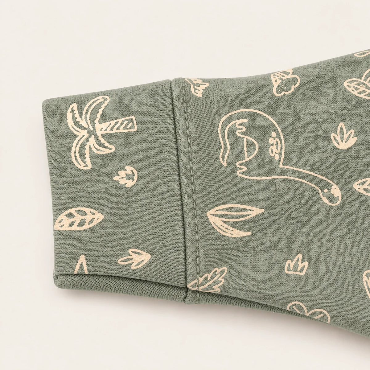 Little Dino | ZB green dinosaur-print footed zipper romper, sleeve and print detail