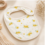 Tiny Blossom | Baby bib angled view on premium neutral background