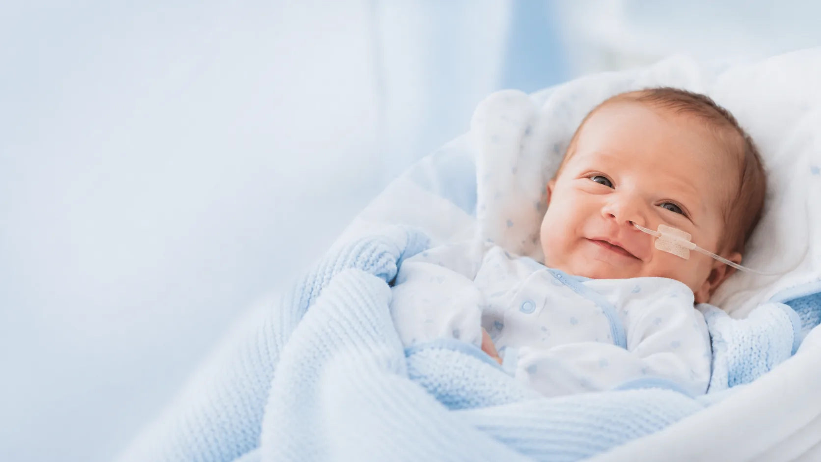 Baby resting in soft blue bedding